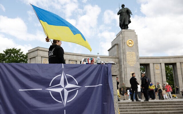 A Ukraine supporter standing behind a NATO flag waves a Ukraine flag at the Soviet War Memorial Tiergarten in Berlin on May 8, 2025, in commemoration of the 80th anniversary of the 1945 victory against Nazi Germany. (Odd ANDERSEN / AFP) A Ukraine supporter standing behind a NATO flag waves a Ukraine flag at the Soviet War Memorial Tiergarten in Berlin on May 8, 2025, in commemoration of the 80th anniversary of the 1945 victory against Nazi Germany. (Odd ANDERSEN / AFP)
