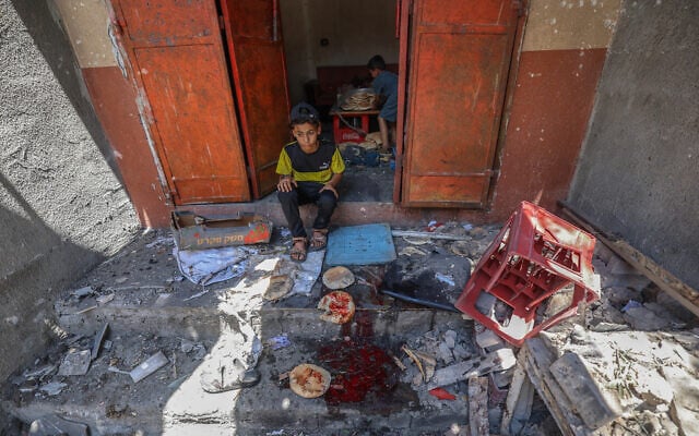 Palestinian boys salvage bread from a makeshift bakery hit in Israeli strikes at the Nuseirat refugee camp in the central Gaza Strip on May 8, 2025. (Eyad BABA / AFP) Palestinian boys salvage bread from a makeshift bakery hit in Israeli strikes at the Nuseirat refugee camp in the central Gaza Strip on May 8, 2025. (Eyad BABA / AFP)