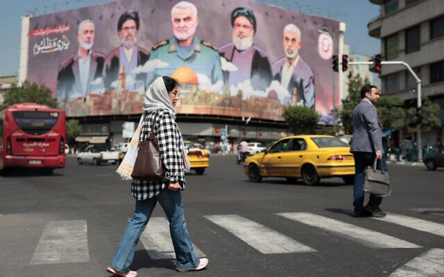 A woman walks past a billboard bearing portraits of slain Iranian and Lebanese and Palestinian terror leaders in Tehran's Enghelab square on May 11, 2025 (ATTA KENARE / AFP) A woman walks past a billboard bearing portraits of slain Iranian and Lebanese and Palestinian terror leaders in Tehran's Enghelab square on May 11, 2025 (ATTA KENARE / AFP)
