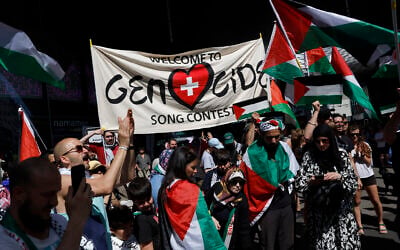 Protesters hold a banner and Palestinian flags as they take part in a demonstration against Israel's candidate during the Eurovision Song Contest 2025 opening ceremony in Basel, Switzerland, on May 11, 2025. (Stefan Wermuth / AFP)