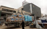 A Palestinian man stands next to a truck carrying UNICEF aid supplies outside a shopping mall in Gaza City on May 12, 2025. (Omar AL-QATTAA / AFP)