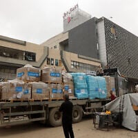 A Palestinian man stands next to a truck carrying UNICEF aid supplies outside a shopping mall in Gaza City on May 12, 2025. (Omar AL-QATTAA / AFP)