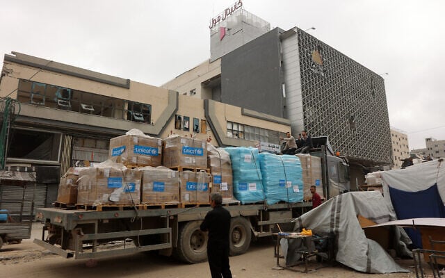 A Palestinian man stands next to a truck carrying UNICEF aid supplies outside a shopping mall in Gaza City on May 12, 2025. (Omar AL-QATTAA / AFP)