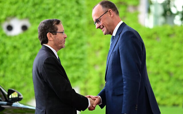 German Chancellor Friedrich Merz (R) welcomes President Isaac Herzog on May 12, 2025 at the Chancellery in Berlin (Tobias SCHWARZ / AFP)