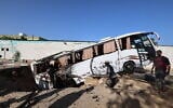 People check a bus inside a crater in the aftermath of an Israeli strike in Khan Younis in the southern Gaza Strip on May 14, 2025 (Eyad BABA / AFP)