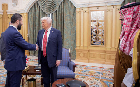 A handout picture provided by the Saudi Royal Palace shows Saudi Crown Prince Mohammed bin Salman (R) watching as US President Donald Trump (C) shakes hands with Syria's interim president Ahmed al-Sharaa in Riyadh on May 14, 2025 (Bandar AL-JALOUD / Saudi Royal Palace / AFP)