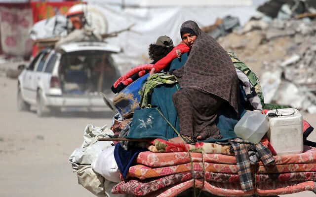A Palestinian woman sits atop her family belongings as people flee Gaza City on May 16, 2025. (Bashar TALEB / AFP)