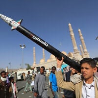 A Yemeni youth carries a mock missile during an anti-Israel rally in solidarity with Palestinians and the Gaza Strip, in the Houthi-run capital Sanaa, May 16, 2025. (Mohammed Huwais/AFP)