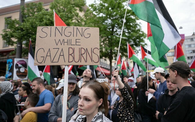 A protester holds a sign during a demonstration against Israel's candidate prior to the grand final of the Eurovision Song Contest 2025 in Basel on May 17, 2025. (Photo by SEBASTIEN BOZON / AFP)