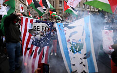 Protesters burn US and Israeli flags during a demonstration against Israel's participation in the Eurovision Song Contest 2025 in Basel, on May 17, 2025. (Sebastien Bozon/AFP)
