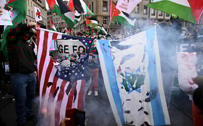 Protesters burn US and Israeli flags during a demonstration against Israel's participation in the Eurovision Song Contest 2025 in Basel, on May 17, 2025. (Sebastien Bozon/AFP)