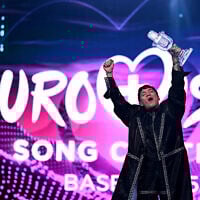 Austrian singer Johannes Pietsch, known as JJ, celebrates with the 2025 Eurovision Song Contest trophy after winning the grand final at the St. Jakobshalle arena in Basel on May 18, 2025. (Fabrice COFFRINI / AFP)