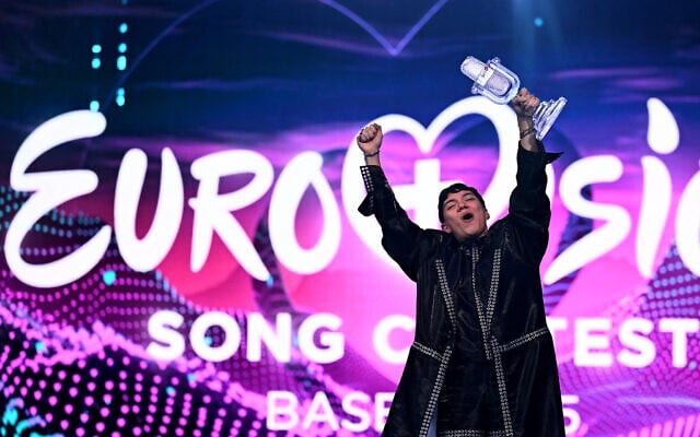 Austrian singer Johannes Pietsch, known as JJ, celebrates with the 2025 Eurovision Song Contest trophy after winning the grand final at the St. Jakobshalle arena in Basel on May 18, 2025. (Fabrice COFFRINI / AFP)
