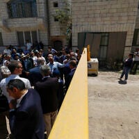 Members of a diplomatic delegation from the European Union stand behind a gate on the eastern entrance of Jenin camp during a visit to the city of Jenin, on May 21, 2025 (Mohammad MANSOUR / AFP)
