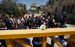 Members of a diplomatic delegation from the European Union stand behind a gate at the eastern entrance of Jenin camp during a visit to the city of Jenin, on May 21, 2025. (Mohammad MANSOUR / AFP)