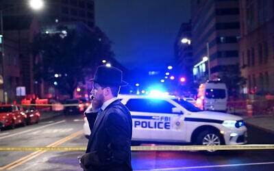 A Jewish man, standing behind US police tape, talks on his cellphone outside the Capital Jewish Museum following a shooting that left two people dead, in Washington, DC, on May 21, 2025. (Alex WROBLEWSKI / AFP)