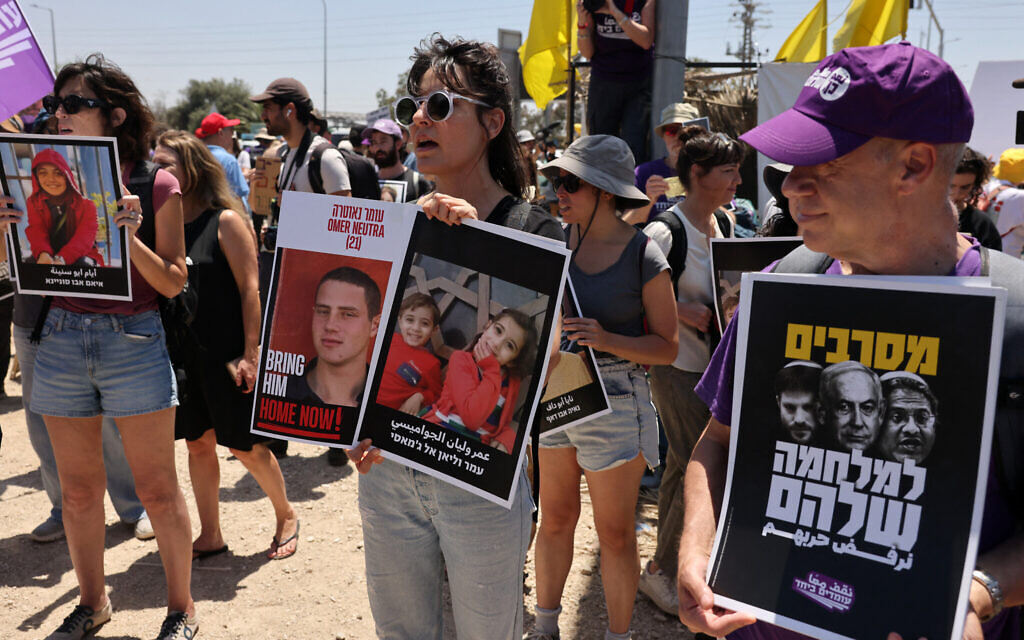 Israeli left-wing activists hold posters during an anti-government demonstration calling for the end of the war in the Gaza Strip and negotiations for the release of hostages held by Hamas, in Shaar HaNegev near Sderot, close to the border with the Palestinian territory, on May 23, 2025. (Ahmad Gharabli/AFP)