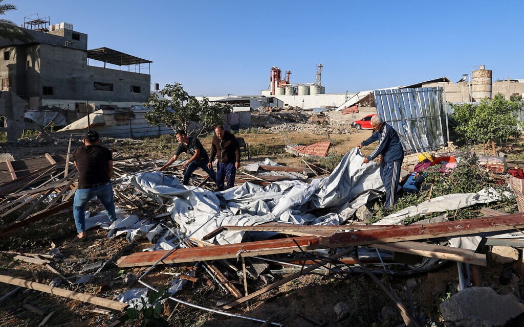 Palestinians looks for salvageable items near a house targeted in an Israeli strike at the Nuseirat camp for refugees in the central Gaza Strip on May 24, 2025. (Eyad BABA / AFP)