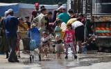Palestinians gather to fill their containers with water in the Nuseirat camp for refugees in the central Gaza Strip on May 24, 2025. (Eyad BABA / AFP)