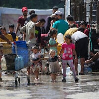 Palestinians gather to fill their containers with water in the Nuseirat camp for refugees in the central Gaza Strip on May 24, 2025. (Eyad BABA / AFP)