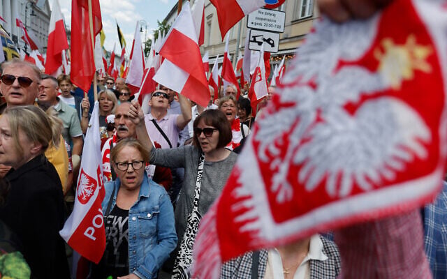 Supporters of Poland's presidential candidate Karol Nawrocki hold Polish flags as they gather to attend a campaign rally in Warsaw on May 25, 2025, a week ahead of the second round of presidential elections. (Photo by Wojtek RADWANSKI / AFP)