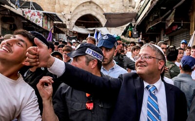 Minister of National Security Itamar Ben Gvir gestures to a supporter as he walks escorted by Israeli police through the Old City of Jerusalem on May 26, 2025, during a flag march for Jerusalem Day. (Menahem Kahana / AFP)