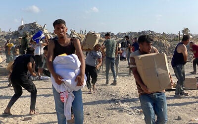 Men hold food packages after Gazans broke into a US-backed foundation pledging to distribute humanitarian aid in western Rafah, in the southern Gaza Strip on May 27, 2025. (AFP)