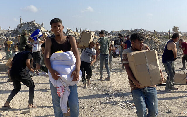 Men hold food packages after Gazans broke into a US-backed foundation pledging to distribute humanitarian aid in western Rafah, in the southern Gaza Strip on May 27, 2025. (AFP)
