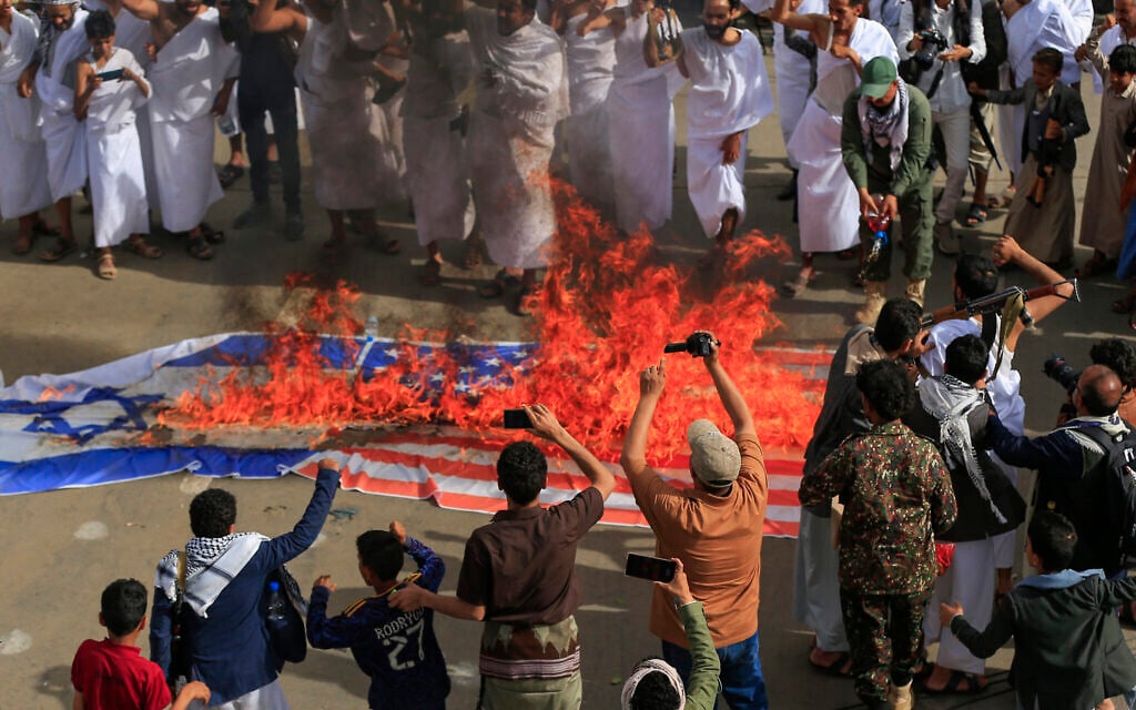 Yemenis, some in Ihram garments worn for the yearly Hajj pilgrimage, burn flags of Israel and the US during a rally in solidarity with Palestinians and the Gaza Strip and in condemnation of Israel and the US, in the Houthi-run capital Sanaa, on May 30, 2025. (Mohammed HUWAIS / AFP)