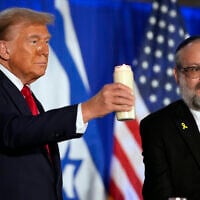 Then-Republican presidential nominee President Donald Trump lights a candle with Rabbi Yehuda Kaploun at an event marking one year since the October 7 Hamas atrocities, October 7, 2024, in Miami. (AP Photo/Alex Brandon)