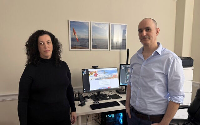 Michal Harel and her husband Avital Epstein show the website they set up to help Israelis navigate a move to Canada in Oakville, Ontario, Canada, December 4, 2024. (AP Photo/Rob Gillies)