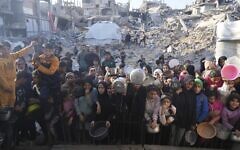 Palestinians wait for donated food at a distribution center in Beit Lahiya, northern Gaza, March 16, 2025. (AP Photo/Abdel Kareem Hana,File)