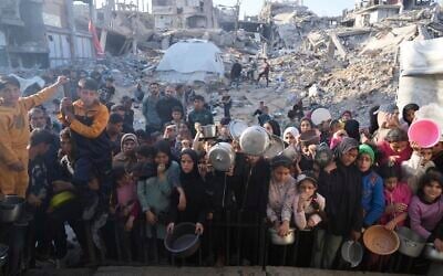 Palestinians wait for donated food at a distribution center in Beit Lahiya, northern Gaza, March 16, 2025. (AP Photo/Abdel Kareem Hana,File)