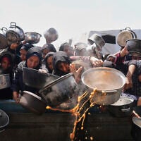 Palestinians struggle to get donated food at a community kitchen in Khan Younis, Gaza Strip, May 5, 2025. (Abdel Kareem Hana/AP)