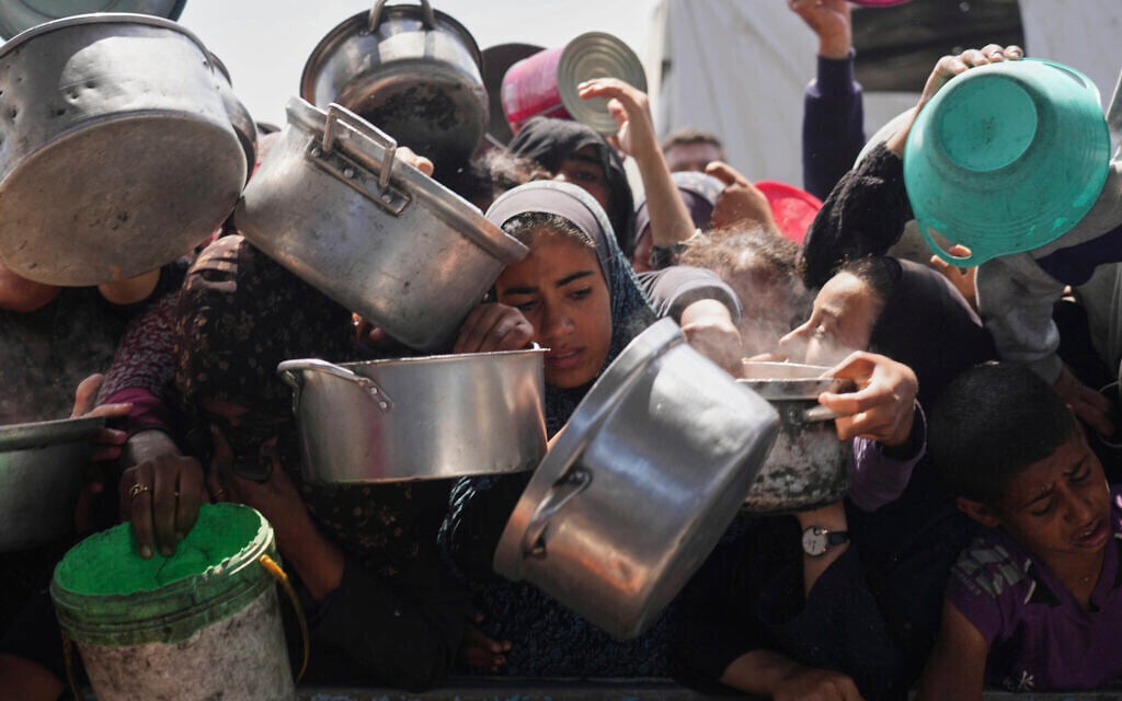 Palestinians struggle to get donated food at a community kitchen in Khan Younis, Gaza Strip, May 5, 2025. (AP Photo/Abdel Kareem Hana)