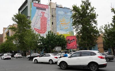 Vehicles drive past an anti-Israel banner showing numerous locations in Israel as a Yemeni dagger (jambiya) with writing in Farsi reading: "All targets are within range, Yemeni missiles for now!" and in Hebrew "All targets are within reach, we will choose," in Tehran, Iran, May 5, 2025. (AP Photo/Vahid Salemi)