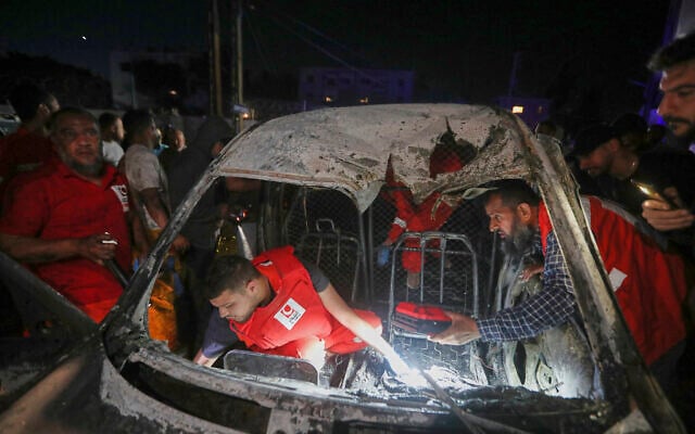 Rescue workers inspect a damaged car after an Israeli strike in the southern port city of Sidon, Lebanon, early Wednesday, May 7, 2025. (AP/Mohammed Zaatari)