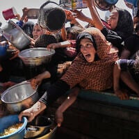 Palestinians struggle to obtain donated food at a community kitchen in Khan Younis, in the southern Gaza Strip, Friday, May 9, 2025. (AP Photo/Abdel Kareem Hana)