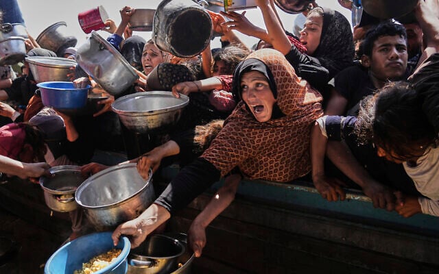 Palestinians struggle to obtain donated food at a community kitchen in Khan Younis, in the southern Gaza Strip, Friday, May 9, 2025. (AP Photo/Abdel Kareem Hana)
