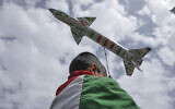 A boy draped in a Palestinian flag carries a mock rocket during a weekly anti-US and anti-Israel rally organized by Houthi supporters in Sanaa, Yemen, May 9, 2025. (AP Photo/Osamah Abdulrahman)