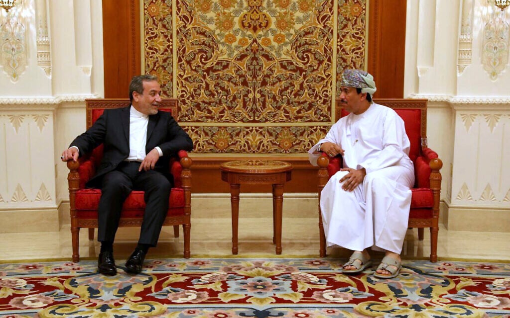 In this photo released by the Iranian Foreign Ministry, Iranian Foreign Minister Abbas Araghchi, left, speaks with an unidentified Omani official upon his arrival in Muscat, Oman, for negotiations with US Mideast envoy Steve Witkoff, May 11, 2025. (Iranian Foreign Ministry via AP)