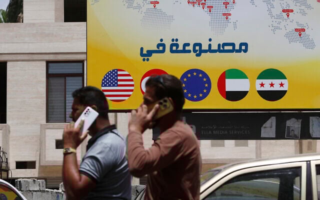 Syrian men speak on their phones on a street in Damascus, Syria, Wednesday, May 14, 2025. (AP/Omar Sanadiki)