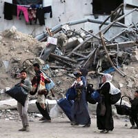 Palestinians evacuate after the Israeli army issued an evacuation warning for several schools and a hospital in Gaza City's Rimal neighborhood, May 14, 2025. (AP Photo/Jehad Alshrafi)