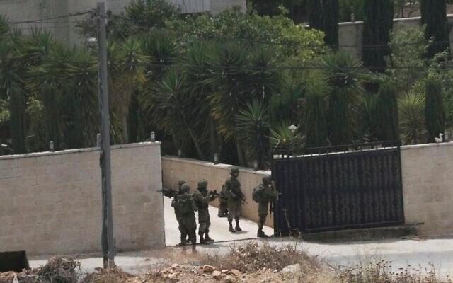 Israeli soldiers search a Palestinian village next to the West Bank settlement of Bruchin after a Palestinian gunman shooting killed Tzeela Gez, who was on her way to the hospital to give birth, May 15, 2025. (AP Photo/Maya Alleruzzo)