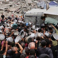 Palestinians struggle to get donated food at a community kitchen in Jabalia, northern Gaza Strip, Thursday, May 15, 2025. (AP Photo/Jehad Alshrafi)