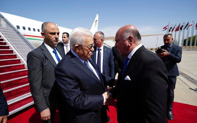 Iraqi Foreign Minister Fuad Hussein, right, welcomes Palestinian Authority President Mahmoud Abbas upon arrival at Baghdad International Airport ahead of the 34th Arab League summit, in Baghdad, Iraq, Friday May 16, 2025. (Murtadha Al-Sudani/Pool Photo via AP)