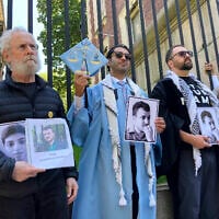 Mohsen Mahdawi, center, holds a photo of Mahmoud Khalil while posing for a photo with demonstrators outside the gates of Columbia University after graduating, Monday, May 19, 2025, in New York. (AP Photo/Jake Offenhartz)