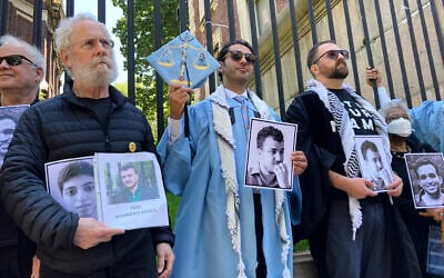 Mohsen Mahdawi, center, holds a photo of Mahmoud Khalil while posing for a photo with demonstrators outside the gates of Columbia University after graduating, Monday, May 19, 2025, in New York. (AP Photo/Jake Offenhartz)