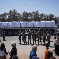 A truck loaded with humanitarian aid for the Gaza Strip makes its way to the Kerem Shalom crossing as Border Police officers prevent activists from blocking the road in southern Israel, May 21, 2025. (AP/Ohad Zwigenberg)