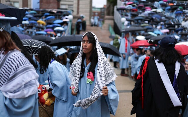 A US student wears a keffiyeh scarf as she walks past other graduates before the Columbia University commencement ceremony on Columbia's main campus, in Manhattan, May 21, 2025 in New York. (Charly Triballeau/Pool Photo via AP) A US student wears a keffiyeh scarf as she walks past other graduates before the Columbia University commencement ceremony on Columbia's main campus, in Manhattan, May 21, 2025 in New York. (Charly Triballeau/Pool Photo via AP)